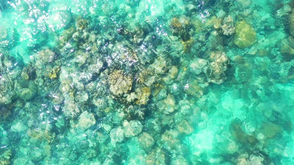 Wide fly over travel shot of a white sand paradise beach and blue ocean background in hi res 