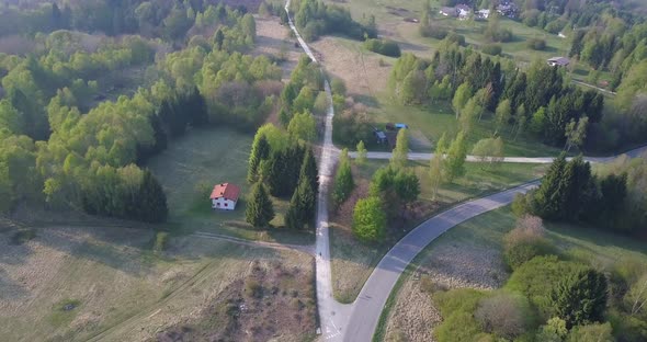 Aerial drone view of a man bike riding in the green countryside hills.