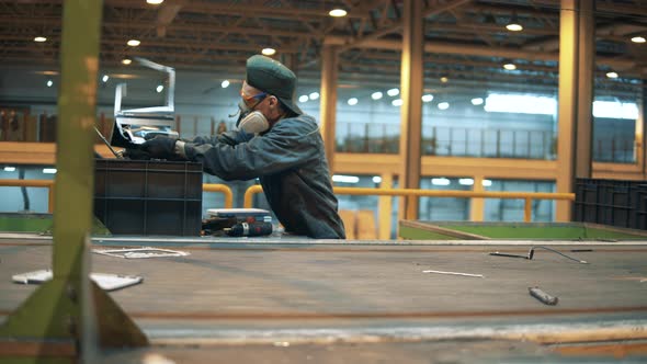 A Person in Uniform Sorts Plastic Trash for Recycling.