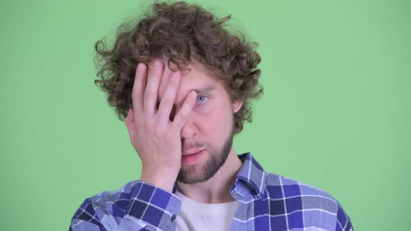 Face of Stressed Young Bearded Hipster Man Showing Face Palm