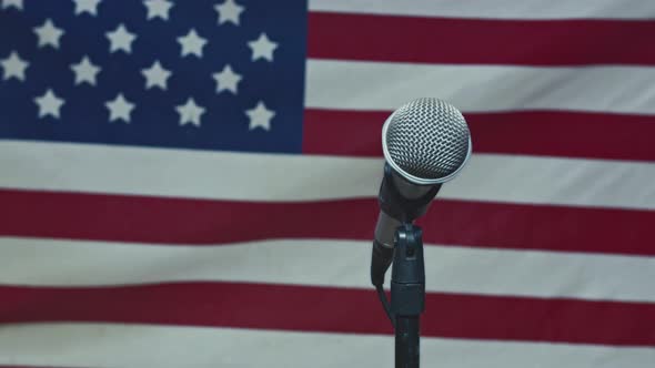 A Microphone In Front Of A Slow Motion USA Flag Ready For A Public Address From The President