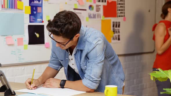 Male business executive writing on a paper