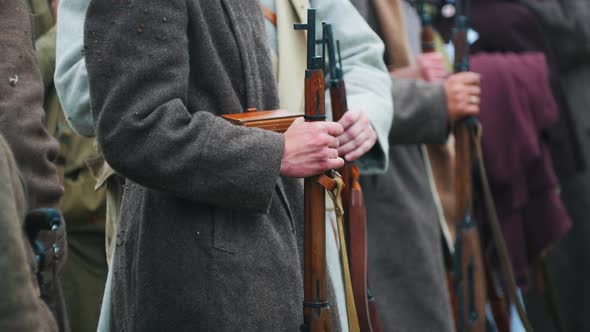 Men Soldiers in Coats Standing in the Row Holding Guns - Clapping with Frozen Hands