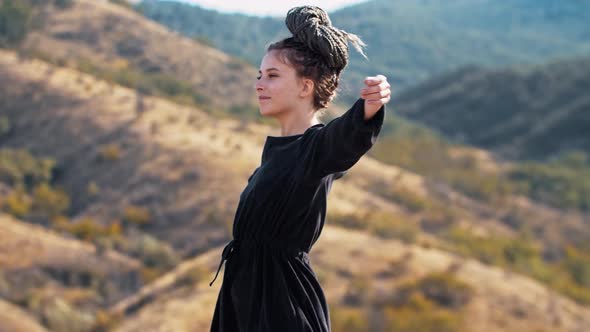 Young Woman with Dreadlocks Walks Up the Hill and Stretching Out