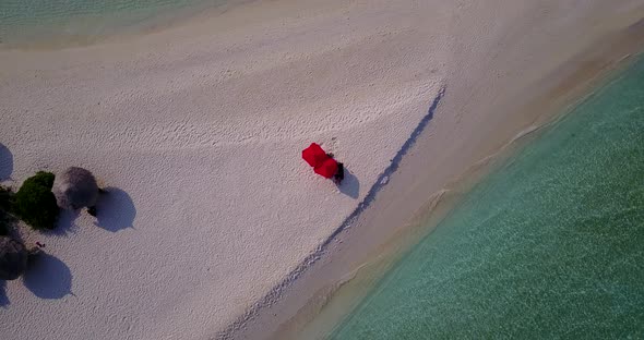 Daytime drone tourism shot of a summer white paradise sand beach and blue water background in vibran