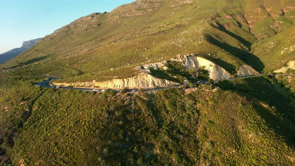 aerial zoom out of Chapmans Peak road at sunset in Cape Town, South Africa