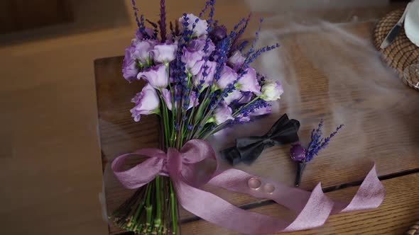 Rings in smoke on table close up. Groom accessory like boutonniere, flowers and butterfly indoors