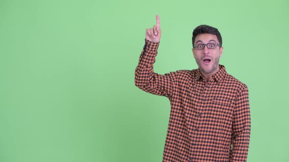 Happy Young Hispanic Hipster Man Pointing Up and Looking Surprised