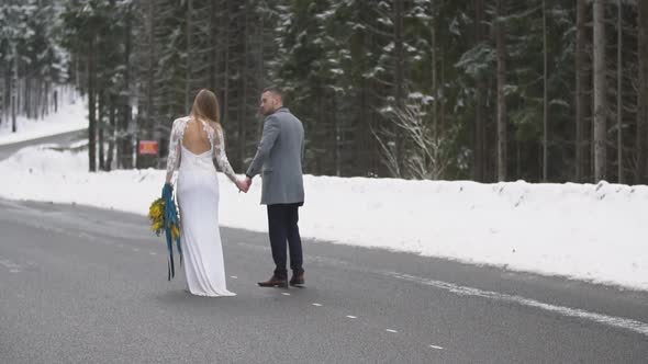 Young Couple Walking on a Road in the Forest