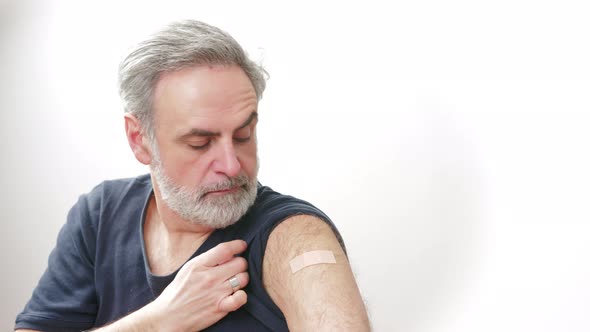 Middleaged Man Showing the Arm Patch After the Vaccination  Immunization Concept