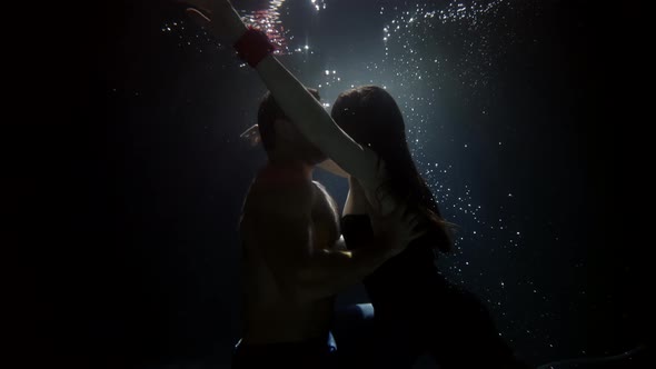 Graceful Pair Is Swimming Underwater and Embracing Kiss Inside Water of Beautiful Woman and Man