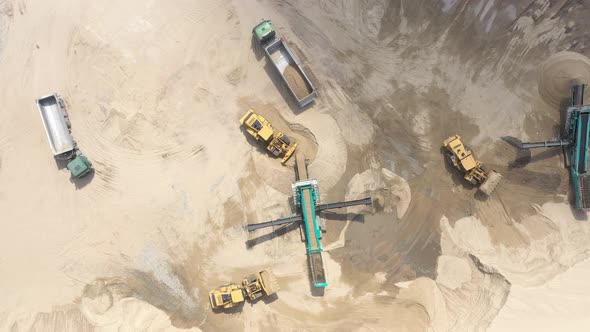 Aerial view loading bulldozer in open air quarry. Sand loading