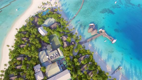 Aerial view of overwaters bungalows connected by a footbridge, Maldives island.