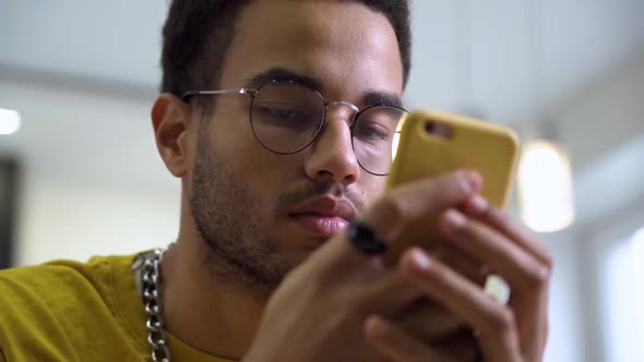 An African Young Man Uses a Smartphone