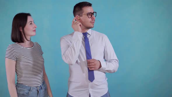 Young Woman Put the Hearing Aid in the Ear Joyful Man on Blue Background