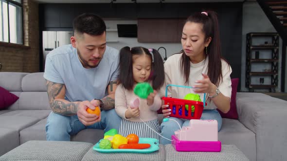 Happy Asian Parents Playing Cognitive Game with Baby Daughter