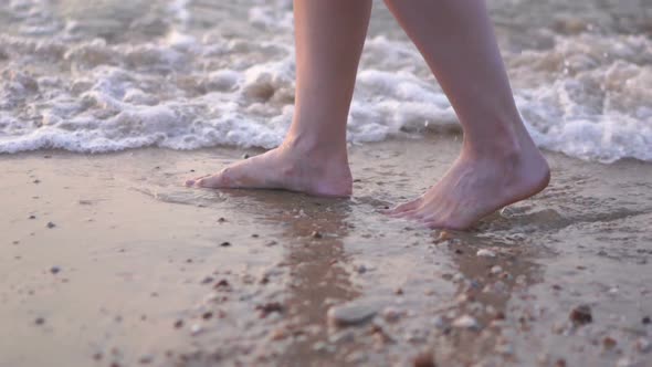 slow motion of woman legs walking on the sea beach