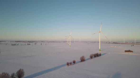 Wind Turbines On The Center Of The Farm Fields In Poland With Colorful Sky On The Background. aerial