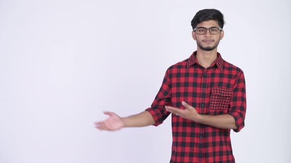 Young Happy Bearded Indian Hipster Man Showing Something