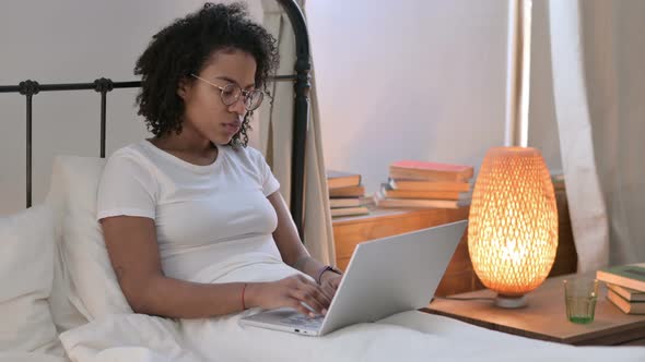 Tired Young African Woman with Laptop, Neck Pain in Bed