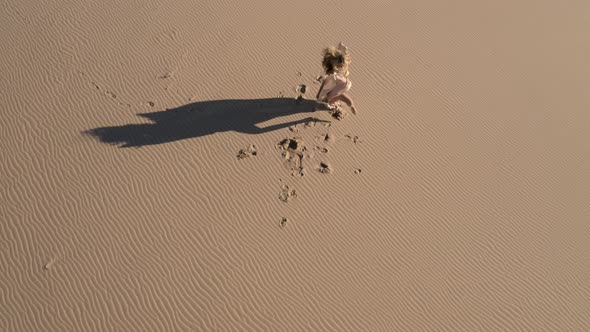 Dancer In Golden Dress On Sandy Beach