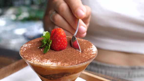 Close Up of a Spoon Taking a Piece of Dairy Free Tiramisu Decorated with Strawberry