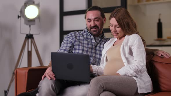 Pregnant Couple Chatting with Relatives on Laptop