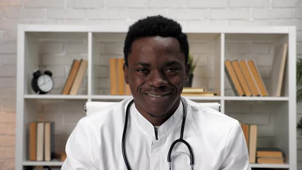 Smiling African American Man Doctor in Medical Coat Looking Camera in Hospital