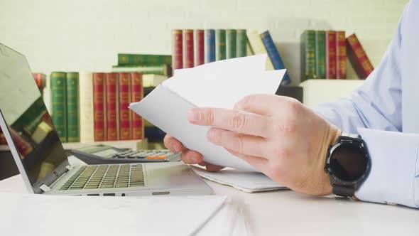 Male Hands with Documents Closeup  a Man at the Workplace in the Office Checks Documents