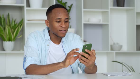 Young African American Business Man Using Phone and Making Winner Gesture with Fist in Office