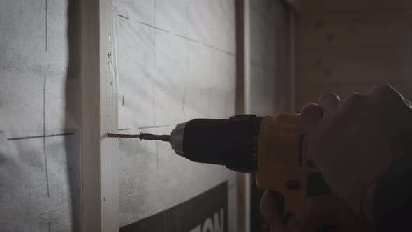 The Worker Tightens the Screw with a Screwdriver