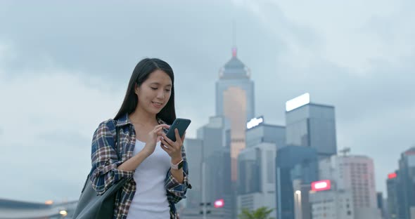 Woman check on mobile phone in city at night