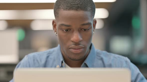 Young African American Man Working on Laptop