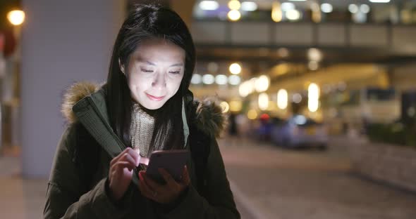 Woman using smart phone at night