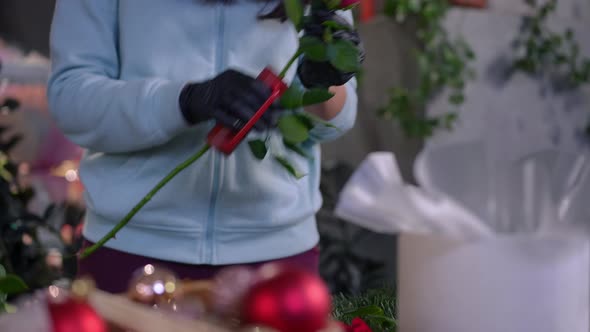 Unrecognizable Florist Cutting Off Needles From Rose Stem in Slow Motion