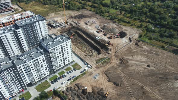 Aerial Shot Heavy Machinery Digs a Pit for the Future Home