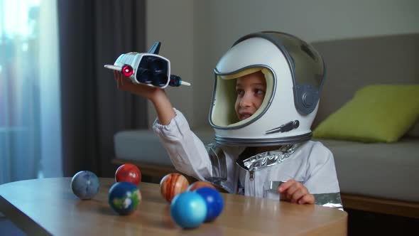 Child Plays at Home in an Astronaut Funny Portrait of a Little Girl 89 Years Old in a Toy Space Suit