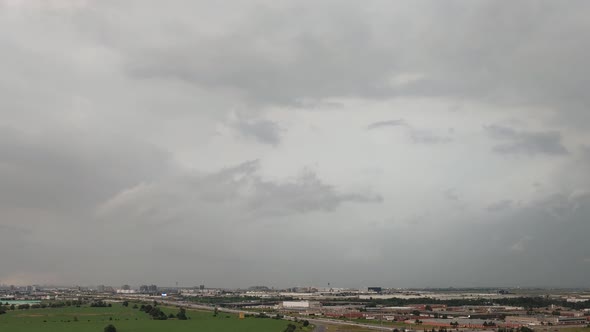 Dark storm clouds with lighting rolling over Toronto city suburbs, time lapse view