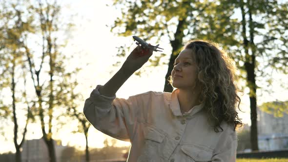 Dreamy Girl Playing Toy Airplane in Park at Sunset, Slow Motion Travel Concept