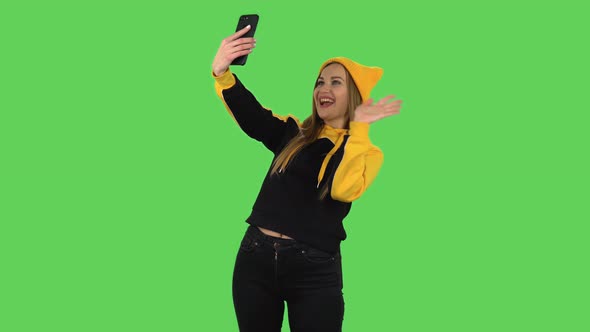 Modern Girl in Yellow Hat Is Talking for Video Chat Using Mobile Phone. Green Screen