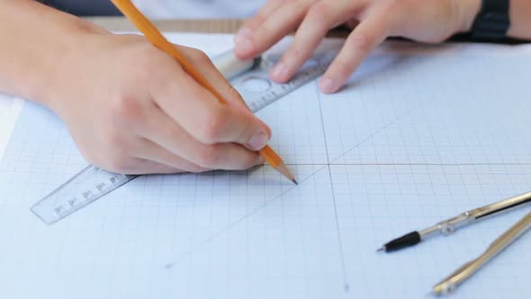 Architect working on a blueprint with a compass. Drawing tools. Creating a drawing.