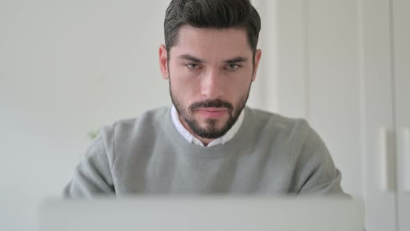 Close Up of Man Reacting to Loss While Using Laptop