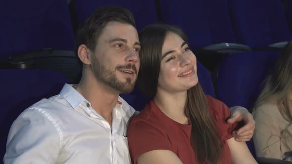 A Nice Guy Presses His Girl Close To Him While Watching a Movie in the Cinema