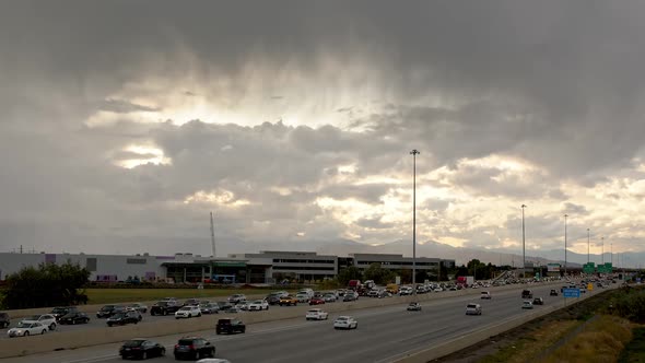 Time lapse of traffic moving on freeway as storm rolls overhead