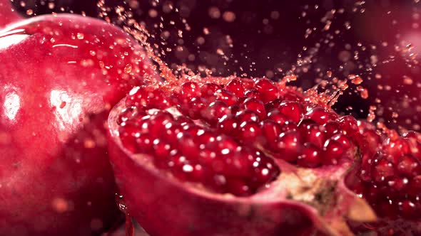 Slow Motion Shot of Pomegranate Juice Splashing Through Pomegranate