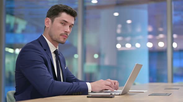 Working Businessman Pointing at the Camera in Office