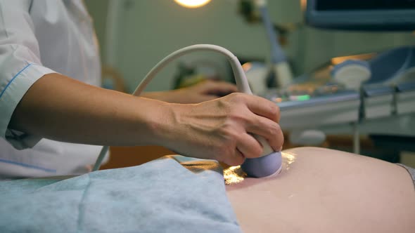 Doctor Is Conducting Stomach Ultrasound with a Detector