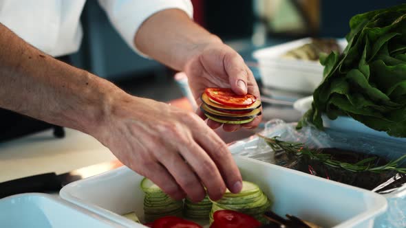 Close-up: The chef gathers vegetables for ratatouille. The process of preparing food