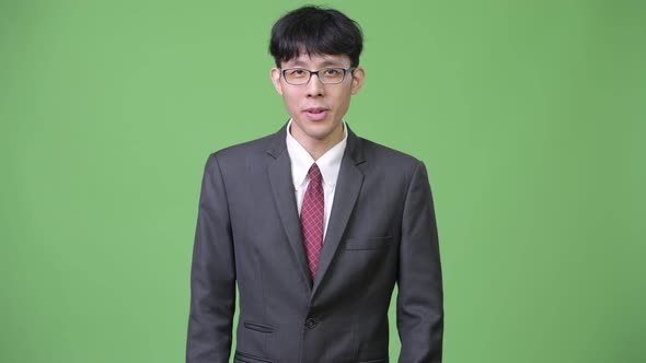 Young Asian Businessman Explaining While Showing Something To the Back