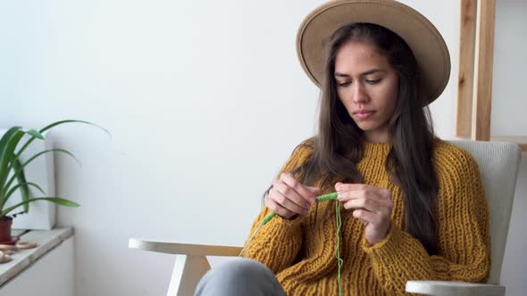 Women's Knitting Young Caucasian Girl Knitting While Sitting on an Armchair at Home Counting Loops